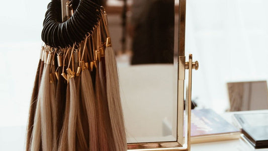 Bohyme professional hair color ring hanging beside a gold-framed mirror and makeup palette.